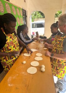 Group cooking session with local women at a community kitchen in Arusha